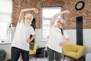 Evde spor yapan iki emekli insan.