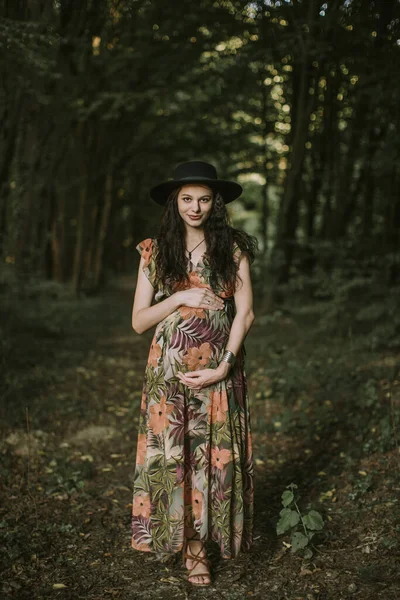 Jolie brune Caucasienne jeune femme enceinte posant dans une belle forêt en plein air — Photo