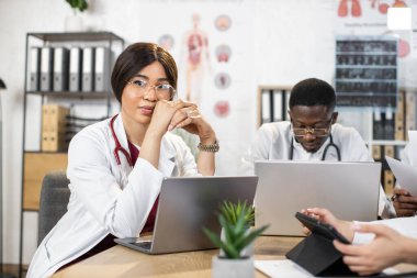Hastanedeki cihazlar üzerinde çalışan çok ırklı meslektaşlar.