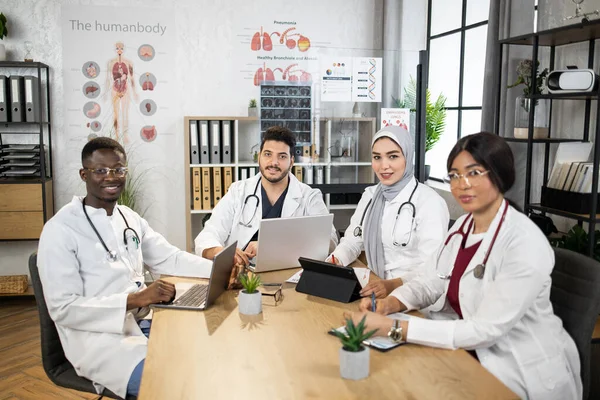 Ofisinde aletleri olan dört uluslararası doktor. — Stok fotoğraf