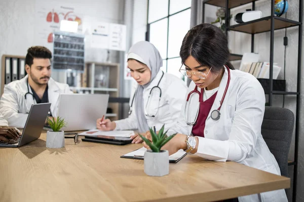 Team multirazziale di medici che lavorano su gadget moderni — Foto Stock