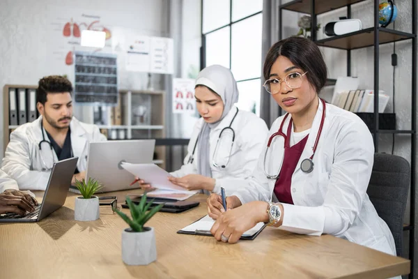 Modern cihazlar üzerinde çalışan çok ırklı doktorlar. — Stok fotoğraf