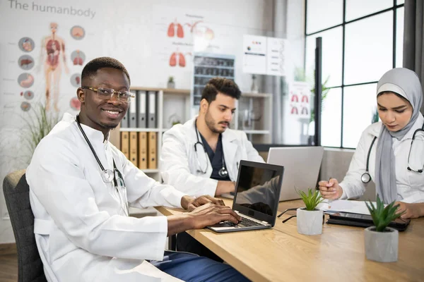 Diversi medici con gadget che si riuniscono in casa — Foto Stock