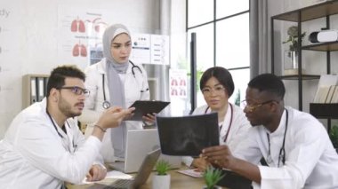 Hasta kafasının röntgen taramasını analiz eden çok ırklı doktorlar.