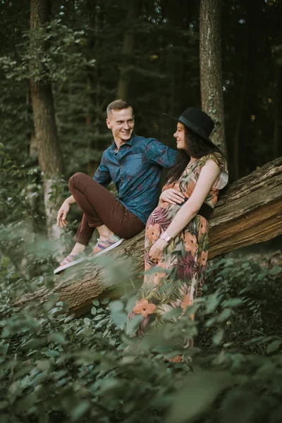 Fille enceinte avec gros ventre mignon et jeune homme dans une belle forêt — Photo