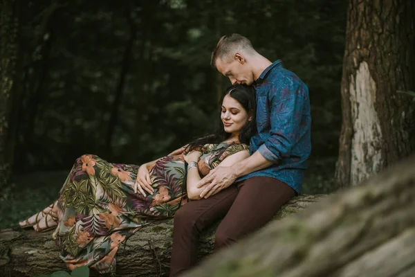 Junge zukünftige Eltern beim Spaziergang im Park oder Wald. — Stockfoto