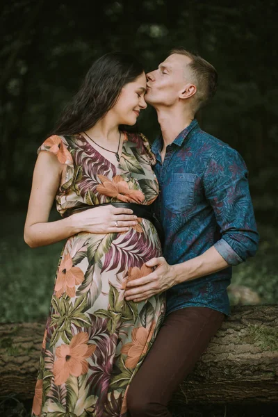 Belle jeune femme enceinte profitant d'une promenade dans la nature avec beau mari, embrassant son visage — Photo