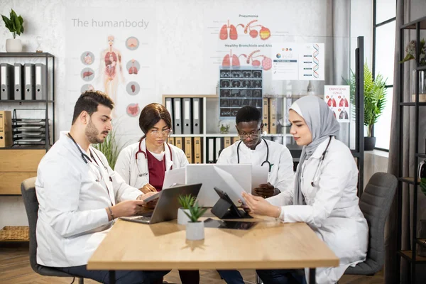 Medici multiculturali che lavorano su gadget in sala conferenze — Foto Stock