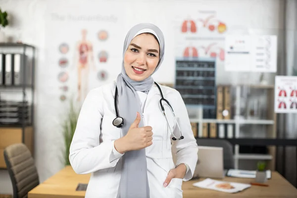 Arab női orvos mutatja hüvelykujját a munkahelyen — Stock Fotó