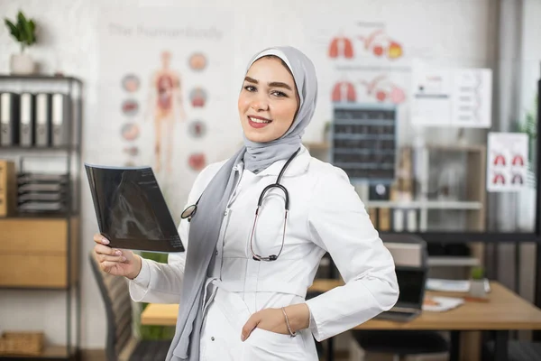 Arab női orvos röntgenképeket analizál a szekrényben. — Stock Fotó