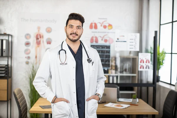 Portrait of confident indian doctor posing at cabinet — Stock Photo, Image