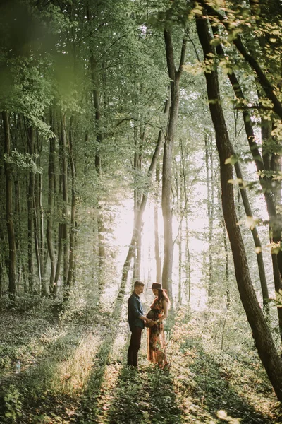 Mulher grávida e homem bonito, de pé cara a cara, andando na floresta — Fotografia de Stock