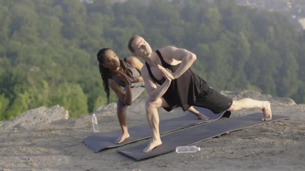 Здоровая и сильная пара, занимающаяся йогой на открытом воздухе — стоковое видео