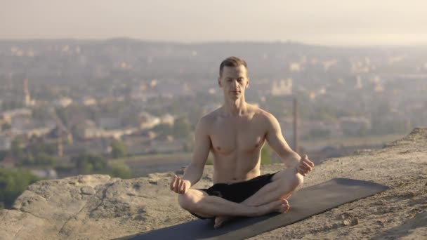 Homme torse nu paisible pratiquant le yoga sur l'air frais — Video