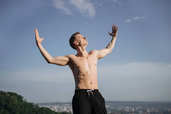 Jovem poderoso com tronco nu em pé ao ar livre — Fotografia de Stock