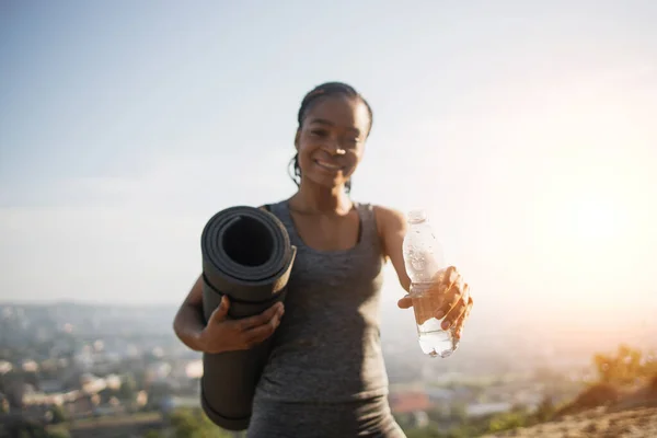 Mulher africana em activewear segurando garrafa de água — Fotografia de Stock