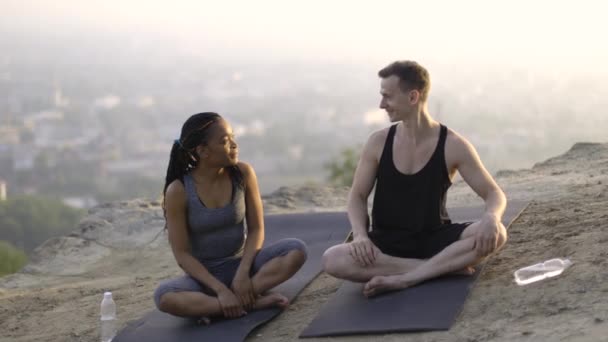 Sporty couple sitting on yoga mat and giving high five — Stock Video