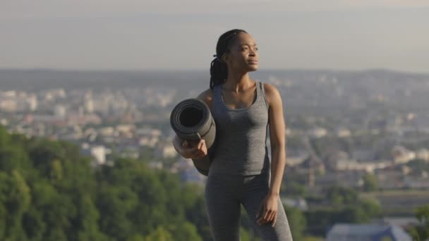 Mujer africana sonriente mostrando sus bíceps al aire libre — Vídeos de Stock