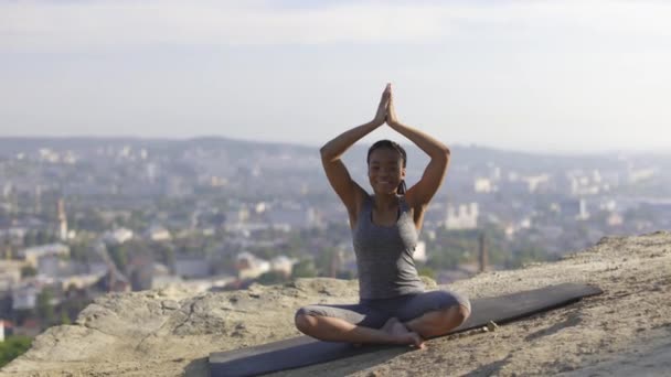 Sportliche Frau praktiziert Yoga auf Matte auf hoher Schanze — Stockvideo