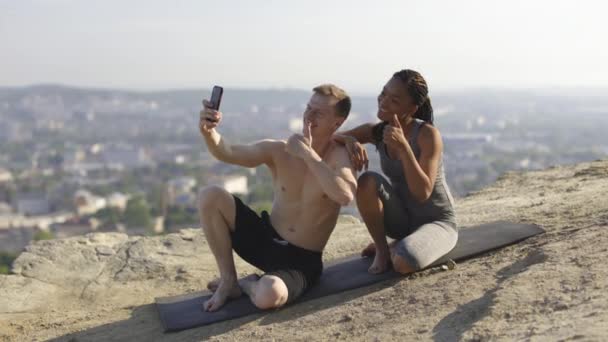 Coppia multirazziale in costume sportivo scattare selfie su smartphone con i pollici in su — Video Stock