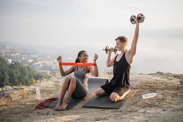 Casal usando elástico e halteres para treino — Fotografia de Stock