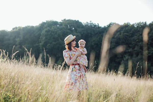 Щаслива красива молода мати і її маленька дочка на літньому полі — стокове фото