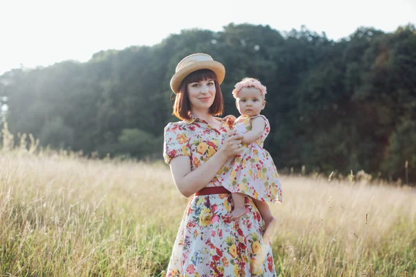 Мати і маленька донька добре проводять час на літньому полі, позує на камеру — стокове фото