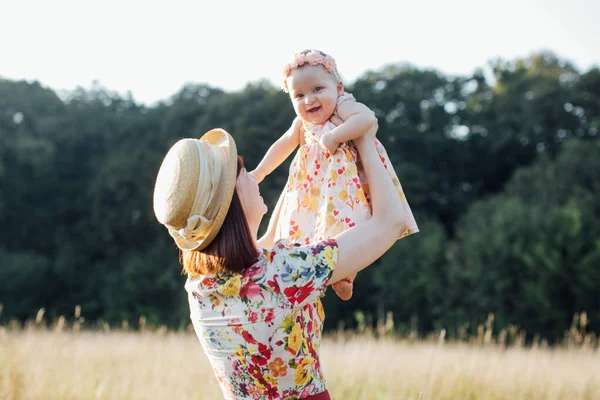 Güzel tarlada ve ağaçların arkasında küçük bir kızı olan neşeli bir anne.. — Stok fotoğraf