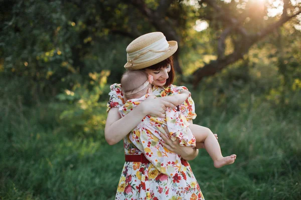 Sevecen anne, tatlı bebeğini elinde tutuyor ve nazikçe sarılıyor. — Stok fotoğraf
