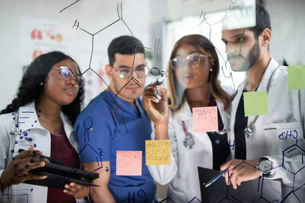 Чоловік Доктор з окулярами вчений пише щось з маркером на склі, стіні — стокове фото
