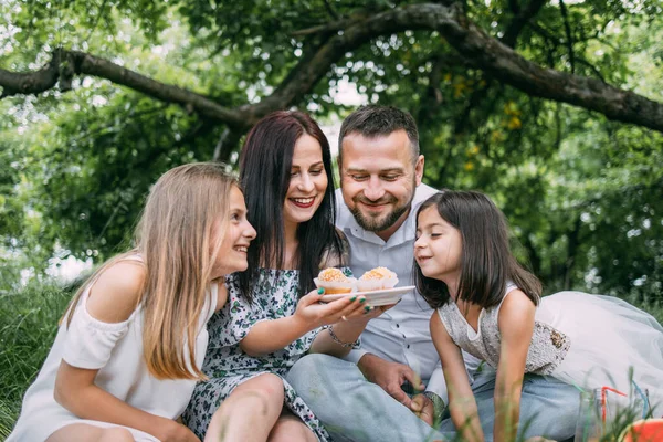 Mutlu aile piknikte lezzetli kekler yiyor. — Stok fotoğraf