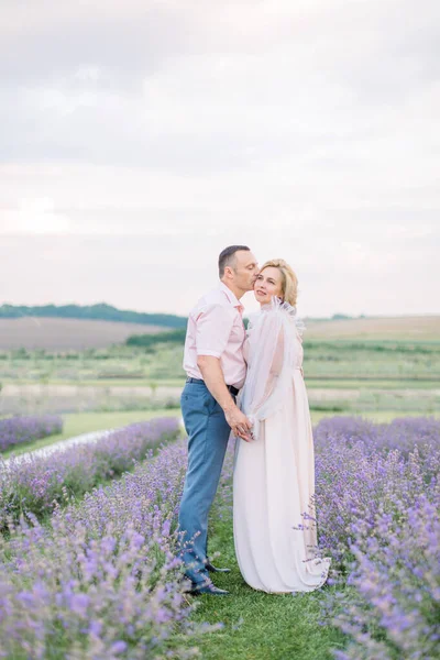 Pareja amorosa romántica madura caminando en el campo de lavanda. —  Fotos de Stock