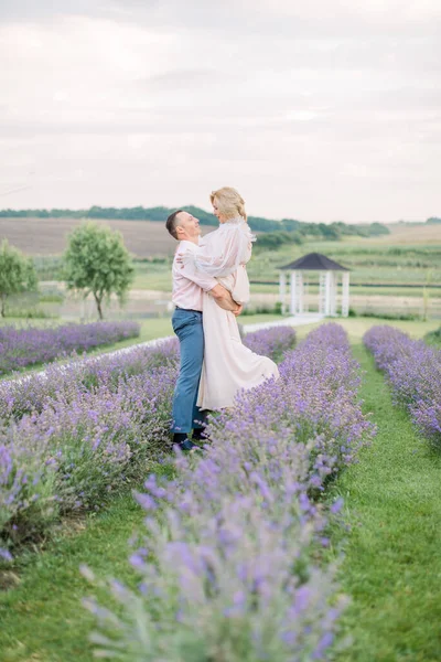 Feliz pareja de mediana edad en un campo de lavanda púrpura — Foto de Stock