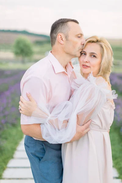 Casal amoroso romântico maduro andando no campo de lavanda. — Fotografia de Stock