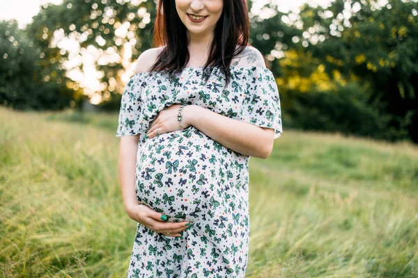 Mujer caucásica embarazada en vestido de verano posando al aire libre —  Fotos de Stock
