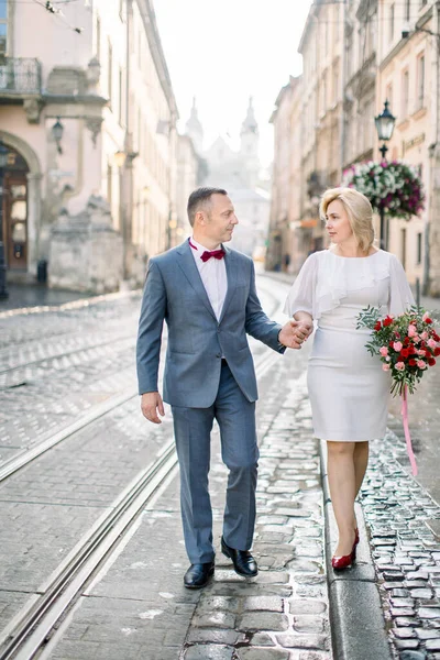 Подружжя середнього віку з любов "ю ходить у елегантному одязі на вулиці у гарному стародавньому європейському місті. — стокове фото