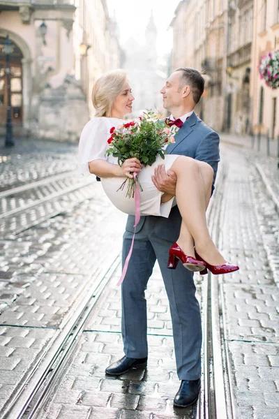 Bella coppia matura all'aperto nella città vecchia sorridente e guardando l'un l'altro — Foto Stock