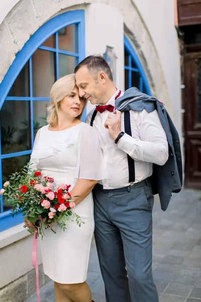 Sorridente felice coppia sposata matura innamorata su un appuntamento nella città vecchia in piedi vicino insieme — Foto Stock