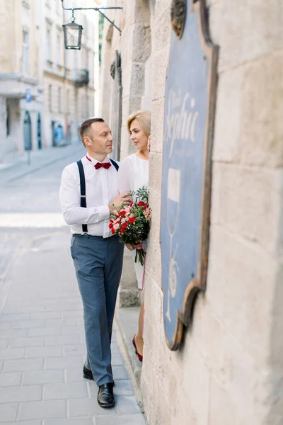 Felice romantica coppia di mezza età, in posa guardando l'un l'altro vicino al vintage edificio della città vecchia — Foto Stock