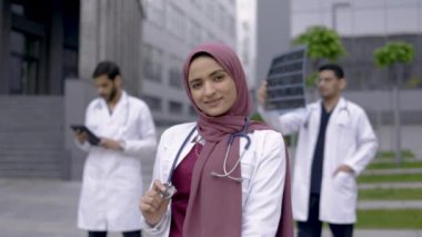 Arabistanlı kadın doktorla birlikte çok ırklı tıbbi ekibin ön görüntüsü.