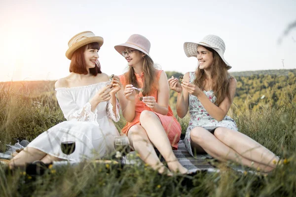 Trois jolies filles tenant des escargots dans les mains et mangeant, sur fond de collines verdoyantes — Photo