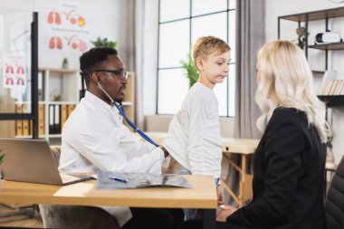 Dinlemek için steteskop tutan doktor küçük çocuğun ciğerleri.