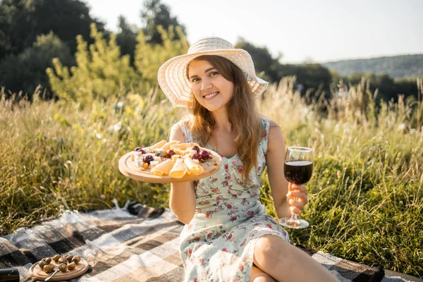 빨간 와인, 치즈, 신선 한 과일 과 함께 여름 잔디밭에서 피크닉을 즐기는 예쁜 소녀 — 스톡 사진