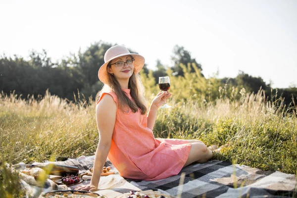 야외에서 피크닉 유리를 들고 있는, 주황색 옷을 입고 모자를 쓴 멋진 여인 — 스톡 사진