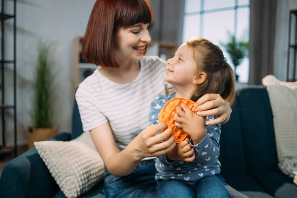 Mãe e sua adorável filhinha brincando com silicone redondo colorido anti stress pop-lo brinquedo — Fotografia de Stock