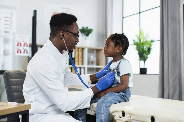 Médico africano usando estetoscópio para ouvir os pulmões das meninas — Fotografia de Stock