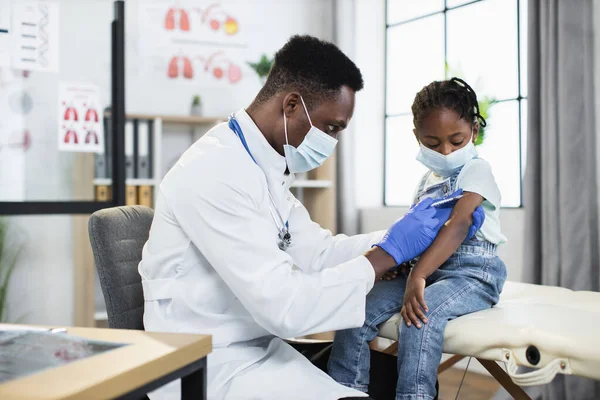 Médecin masculin vaccinant une petite fille du coronavirus — Photo