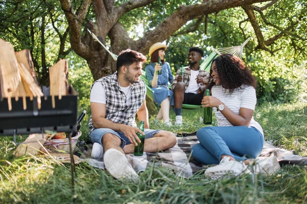 Quatre amis joyeux pique-niquent au jardin d'été — Photo