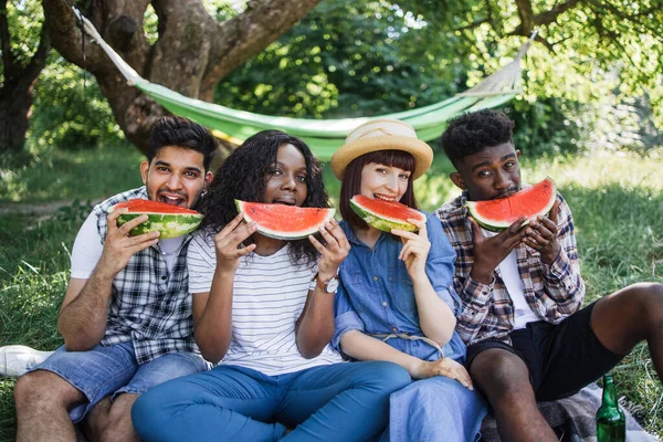 Peuple multiculturel mangeant pastèque mûre sur pique-nique — Photo