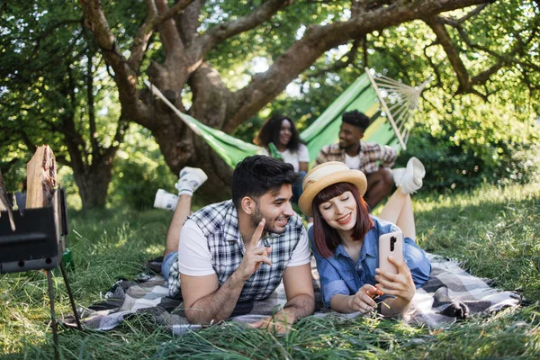 Peopel multiracial avec mobile et boissons sur pique-nique — Photo